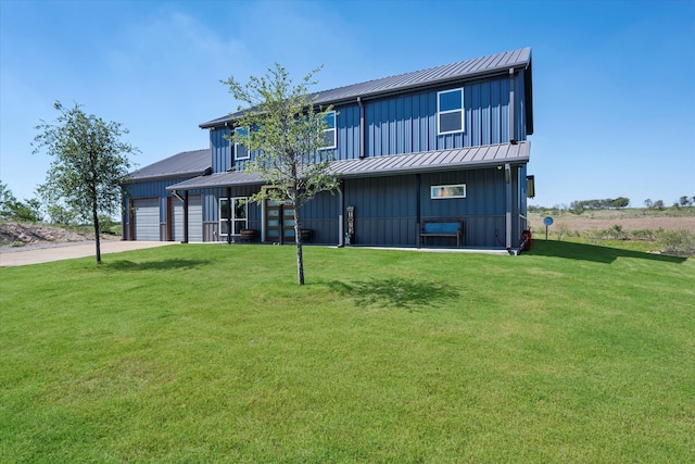 rear view of house featuring a garage and a yard