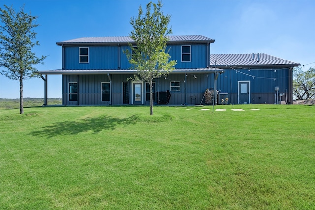 rear view of property featuring a lawn