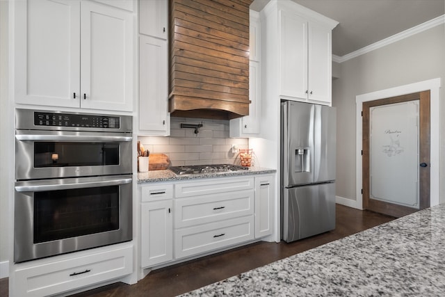 kitchen with light stone countertops, white cabinets, stainless steel appliances, tasteful backsplash, and ornamental molding