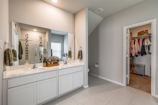 bathroom featuring toilet, tile patterned floors, a shower with shower door, and vanity