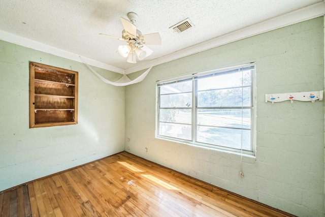 unfurnished room with hardwood / wood-style flooring, ceiling fan, and a textured ceiling