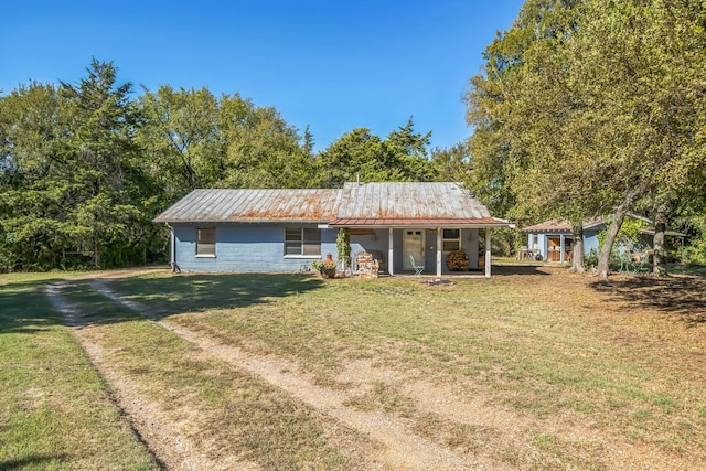 single story home with an outbuilding, covered porch, and a front yard