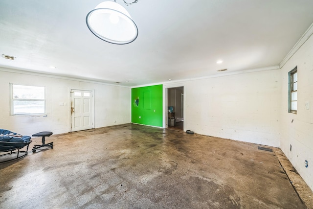 unfurnished room featuring concrete floors and ornamental molding