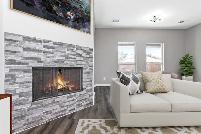 living room featuring a stone fireplace and hardwood / wood-style floors