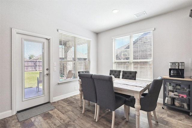 dining space with visible vents, baseboards, and wood finished floors