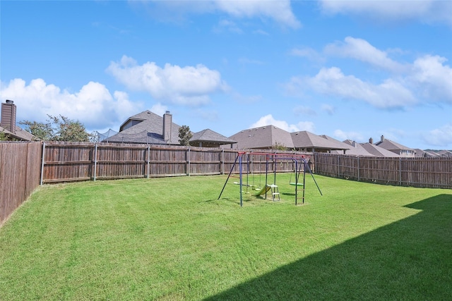 view of yard featuring a fenced backyard, a playground, and a residential view