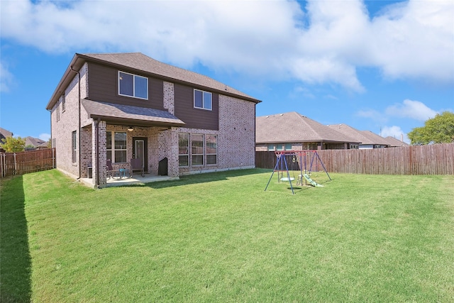 back of property with a shingled roof, a lawn, a fenced backyard, a patio, and brick siding