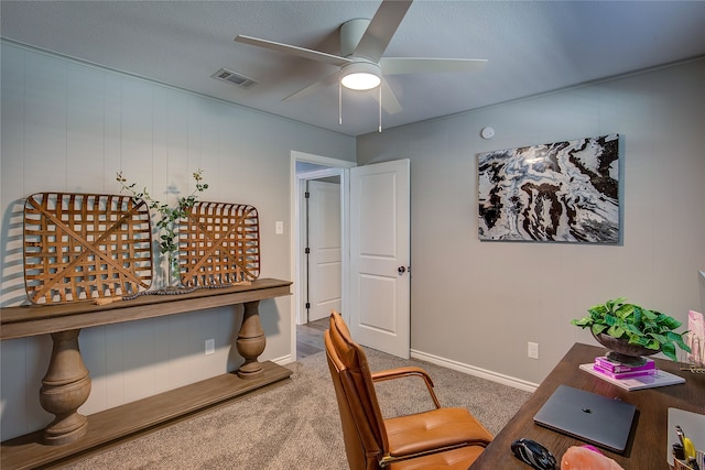 carpeted home office with ceiling fan and a textured ceiling