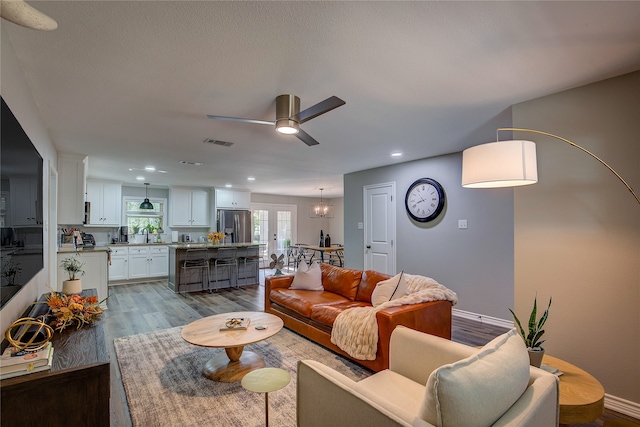 living room featuring hardwood / wood-style flooring, ceiling fan, and sink