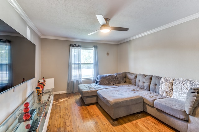 living room with a textured ceiling, crown molding, light hardwood / wood-style floors, and ceiling fan