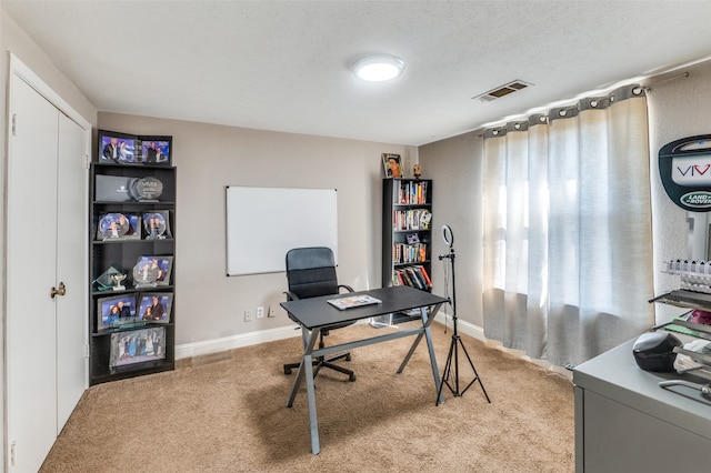 office featuring light carpet and a textured ceiling