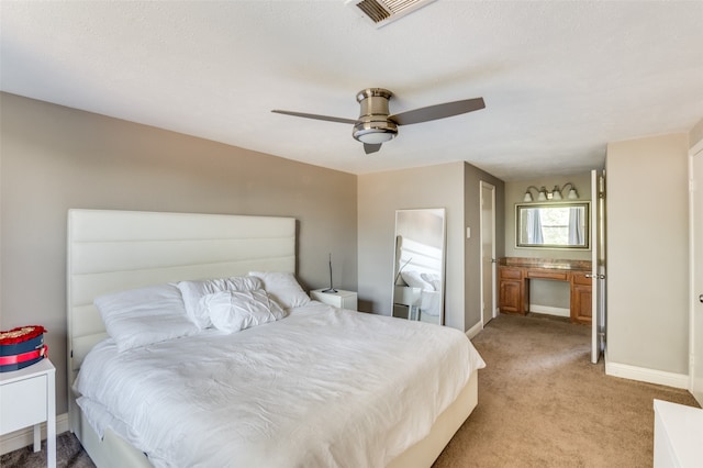 carpeted bedroom featuring ceiling fan and a textured ceiling