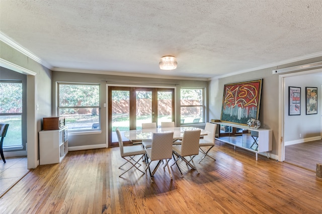 dining area featuring ornamental molding, a textured ceiling, and light hardwood / wood-style floors