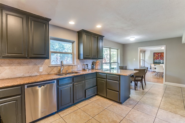 kitchen with light tile patterned floors, sink, a textured ceiling, dishwasher, and decorative backsplash