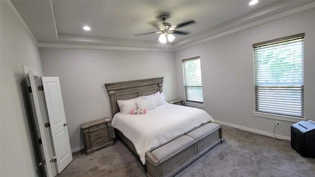 bedroom featuring light carpet, ceiling fan, a raised ceiling, and crown molding