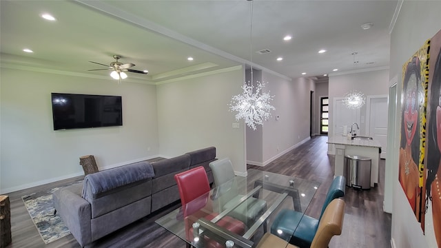 living room with ceiling fan with notable chandelier, crown molding, and dark hardwood / wood-style flooring