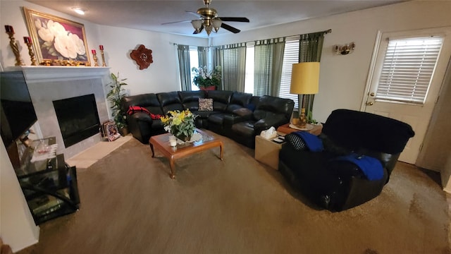 living room with a high end fireplace and ceiling fan