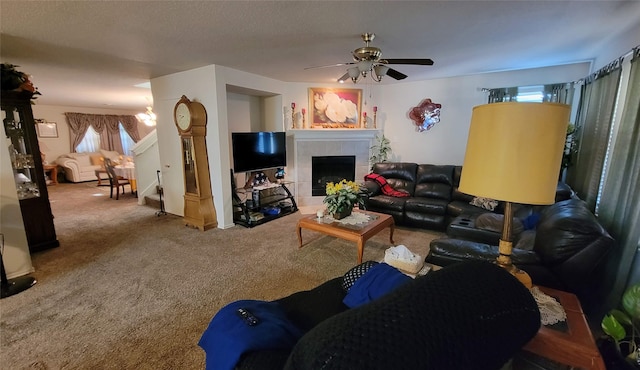 carpeted living room with a tile fireplace and ceiling fan