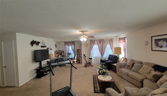 living room featuring ceiling fan, light colored carpet, and a textured ceiling