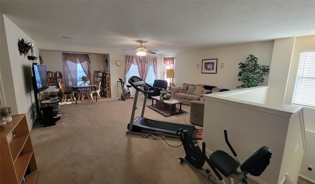 exercise area featuring a textured ceiling, carpet floors, and ceiling fan