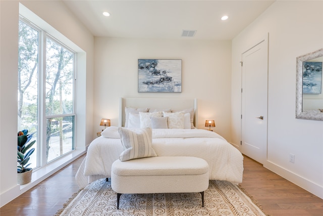 bedroom featuring multiple windows and hardwood / wood-style floors