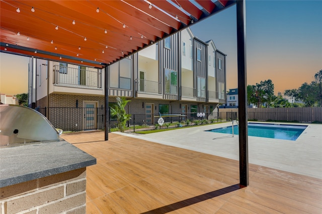 pool at dusk featuring a patio area