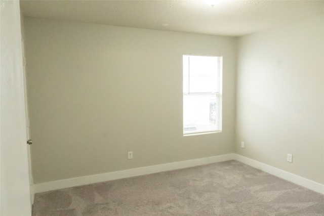 carpeted empty room featuring a textured ceiling