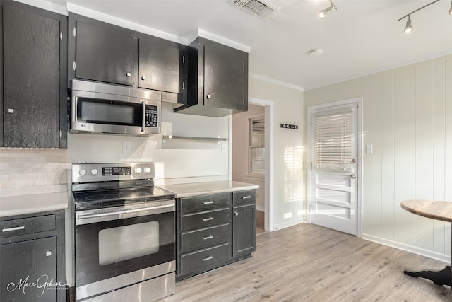 kitchen featuring ornamental molding, stainless steel appliances, backsplash, and light hardwood / wood-style floors