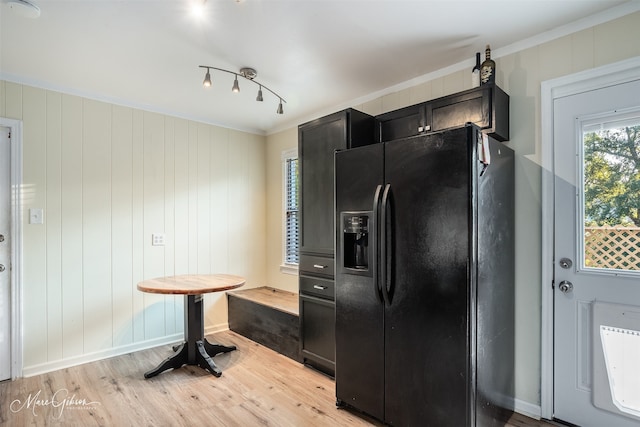 kitchen featuring wooden walls, black fridge with ice dispenser, ornamental molding, and light hardwood / wood-style flooring