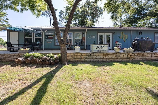 back of property featuring a lawn, french doors, and a patio area