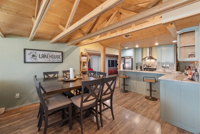 dining area with vaulted ceiling with beams, hardwood / wood-style flooring, and wooden ceiling