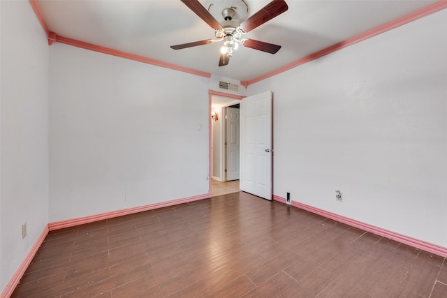 spare room with ceiling fan, crown molding, and dark wood-type flooring