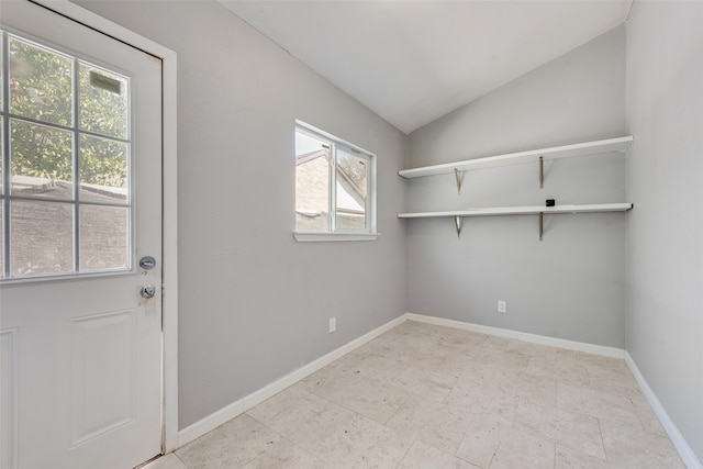 doorway to outside featuring vaulted ceiling and plenty of natural light