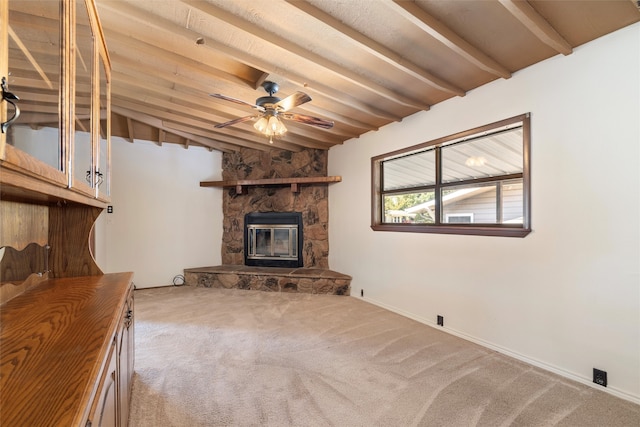 unfurnished living room featuring a fireplace, carpet flooring, lofted ceiling with beams, and ceiling fan