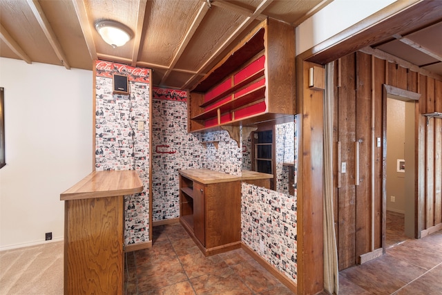 interior space featuring wood walls and dark tile patterned flooring