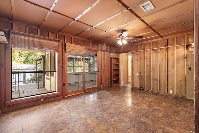 spare room with wooden walls and ceiling fan