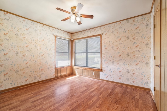 spare room with wood-type flooring, ceiling fan, and crown molding