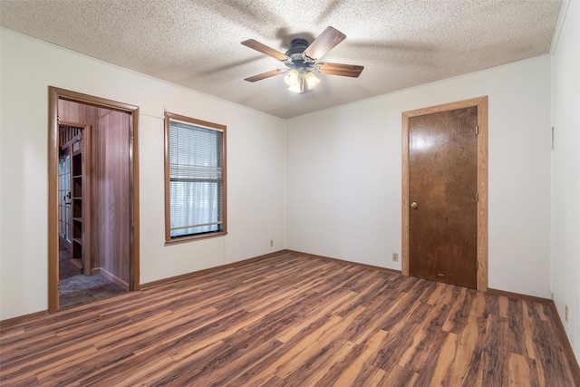 unfurnished room featuring ceiling fan, a textured ceiling, and dark hardwood / wood-style floors