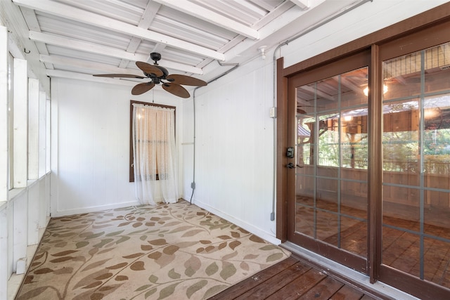 unfurnished sunroom featuring ceiling fan and beam ceiling