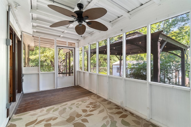 unfurnished sunroom featuring ceiling fan