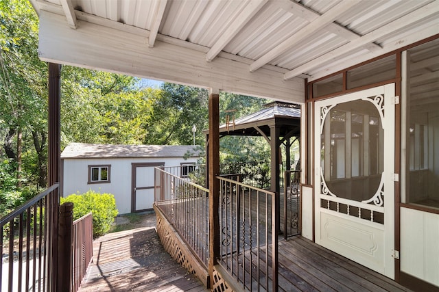 wooden deck with a storage shed and a gazebo