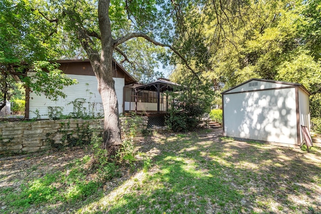 view of yard with a storage shed, a deck, and a gazebo