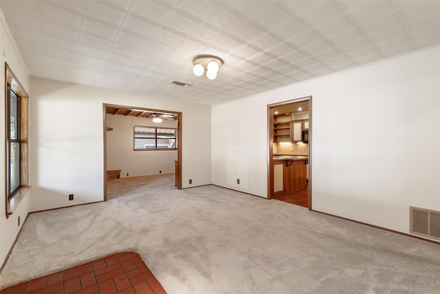 unfurnished room with ornamental molding, ceiling fan, and light colored carpet