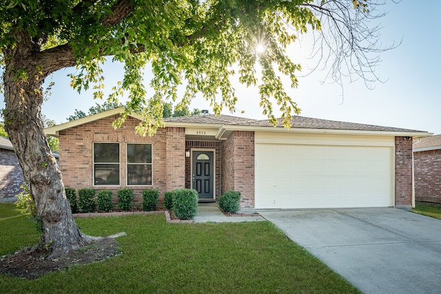 ranch-style home with a garage and a front lawn