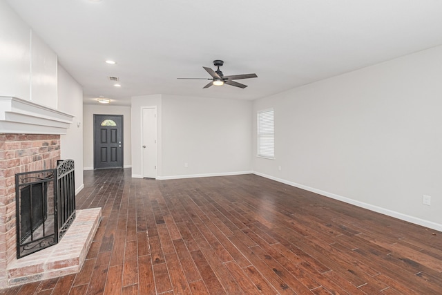 unfurnished living room with dark hardwood / wood-style floors, ceiling fan, and a brick fireplace