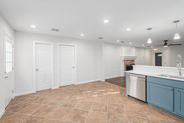 kitchen featuring sink, a brick fireplace, ceiling fan, blue cabinetry, and stainless steel dishwasher