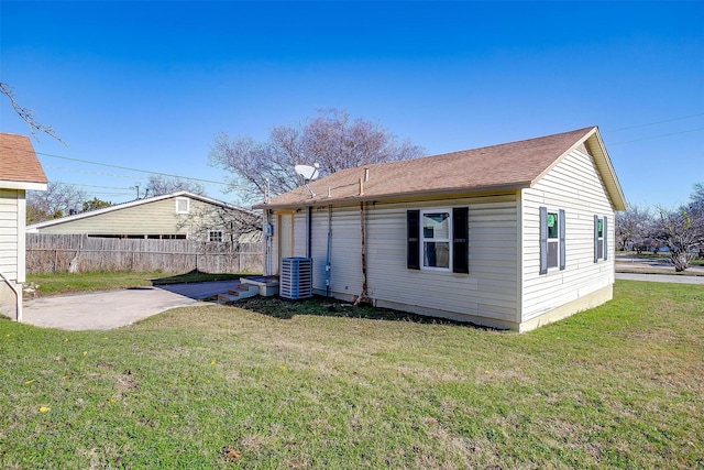 rear view of property with a lawn, a patio area, and central AC