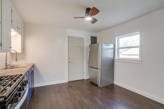 kitchen featuring white cabinetry, sink, ceiling fan, stainless steel appliances, and dark hardwood / wood-style flooring