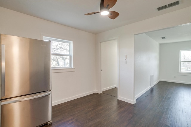 kitchen with stainless steel fridge, plenty of natural light, and dark wood-type flooring