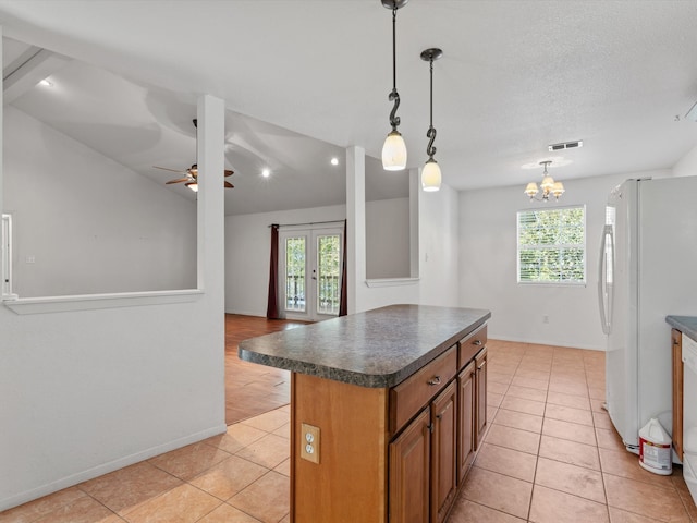 kitchen with french doors, white refrigerator, pendant lighting, a kitchen island, and ceiling fan with notable chandelier